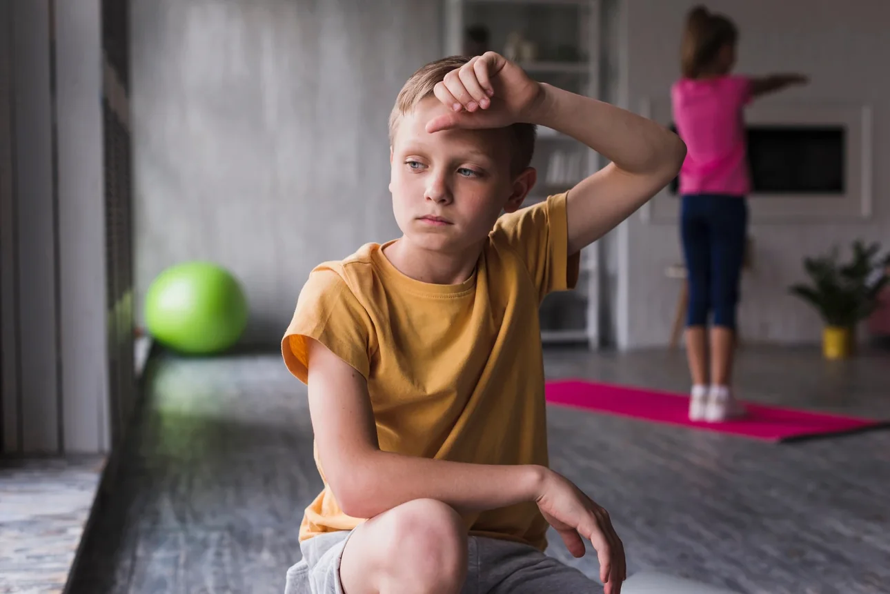 Tired young athlete sitting on the floor